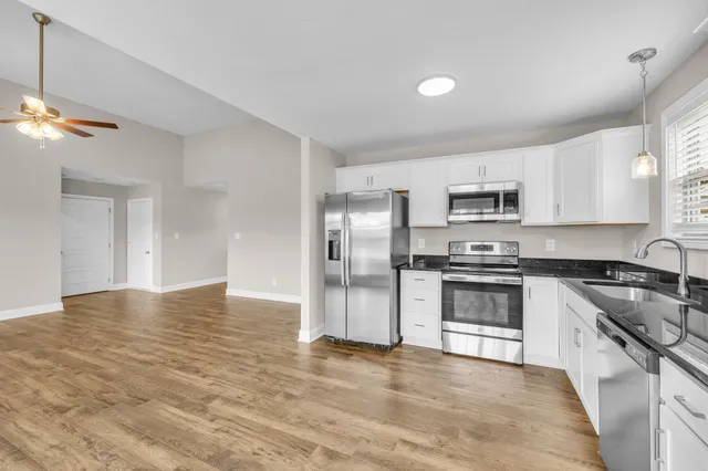 a kitchen with cabinets stainless steel appliances and a window