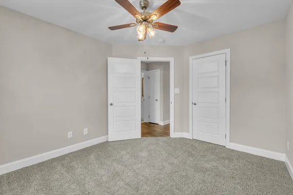 an empty room with a ceiling fan and window