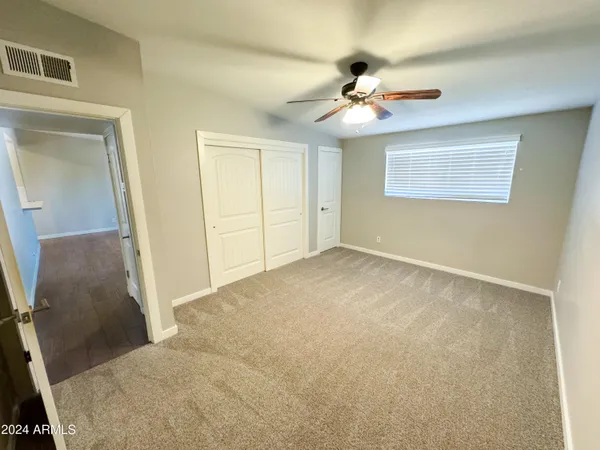 a view of an empty room with a chandelier fan