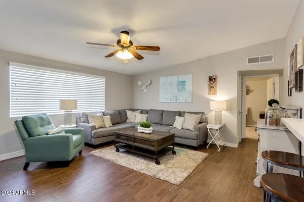 a living room with furniture a ceiling fan and a window