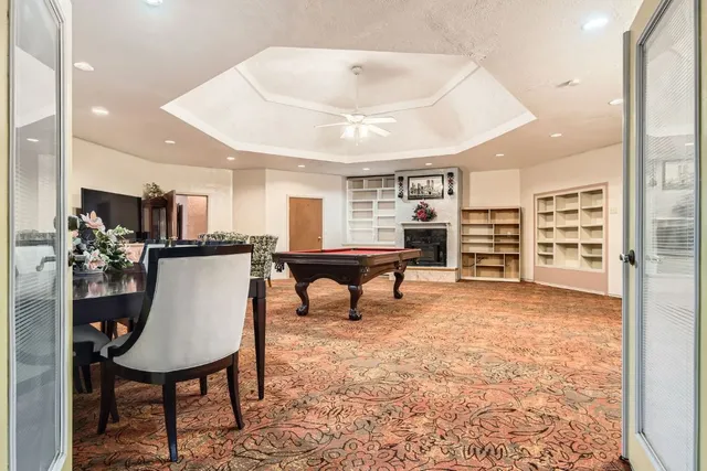a living room with furniture a kitchen view and a large window