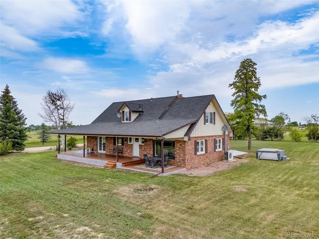 a view of a house with a big yard and large trees