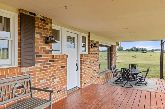 a view of a hallway with wooden floor and a living room