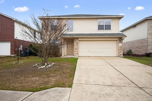 a front view of a house with a yard and garage