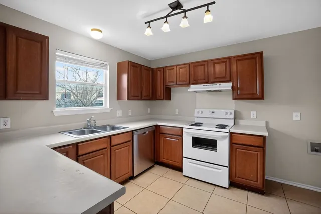 a kitchen with stainless steel appliances granite countertop a sink window and cabinets
