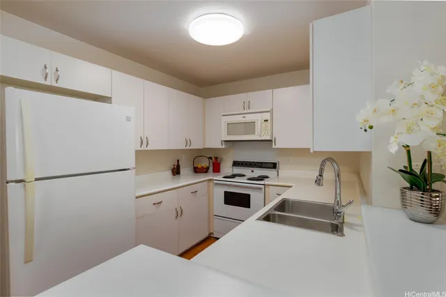 a kitchen with white cabinets and white appliances