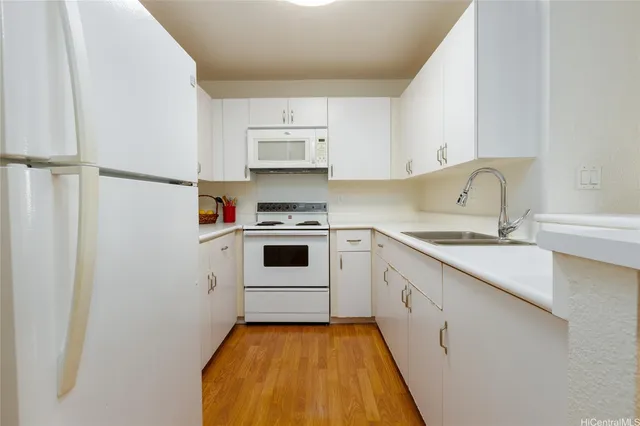 a kitchen with white cabinets sink and white appliances