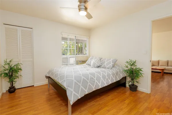 a bed sitting in a spacious bedroom next to a window