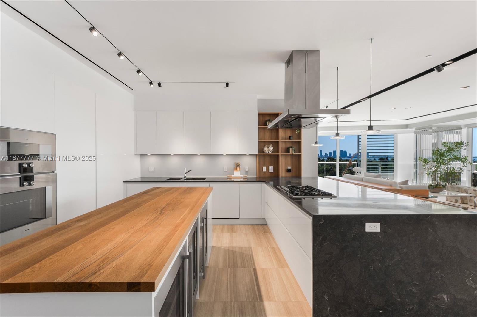 4701 Meridian Avenue, Unit 512 Miami Beach, FL 33140 - Photo 13 of 60 a kitchen with kitchen island granite countertop a sink stove and wooden cabinets