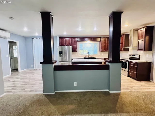 a view of an empty room with a fireplace and a window