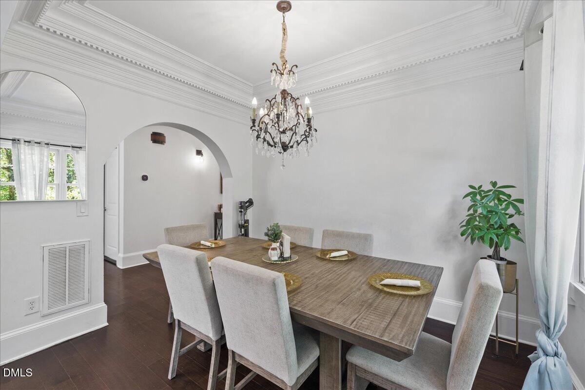 1304 Flying Hawk Road Apex, NC 27523 - Photo 10 of 52 a view of a dining room with furniture a chandelier and wooden floor