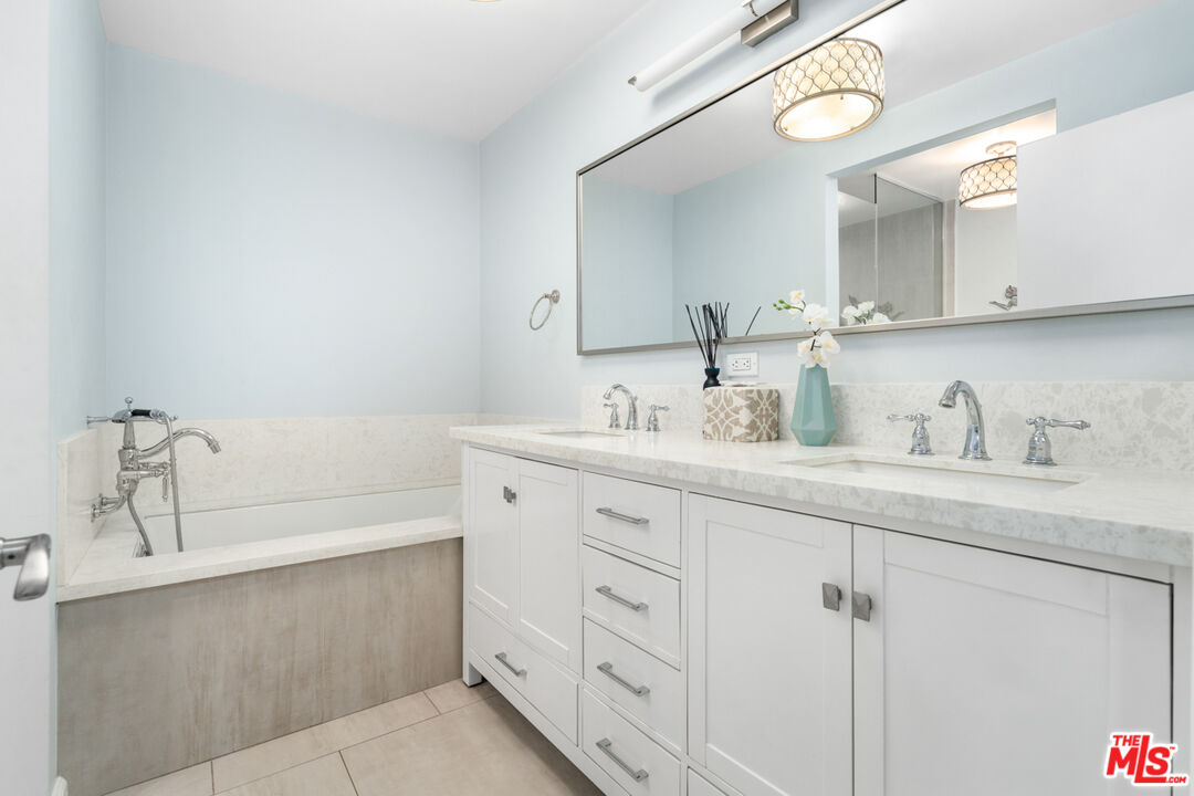 4150 Vía Dolce, Unit 236 Venice, CA 90292 - Photo 16 of 26 a bathroom with a granite countertop sink mirror and bathtub