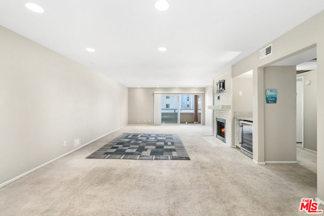 4150 Vía Dolce, Unit 236 Venice, CA 90292 - Photo 7 of 26 a spacious bedroom with a bed and a view of kitchen