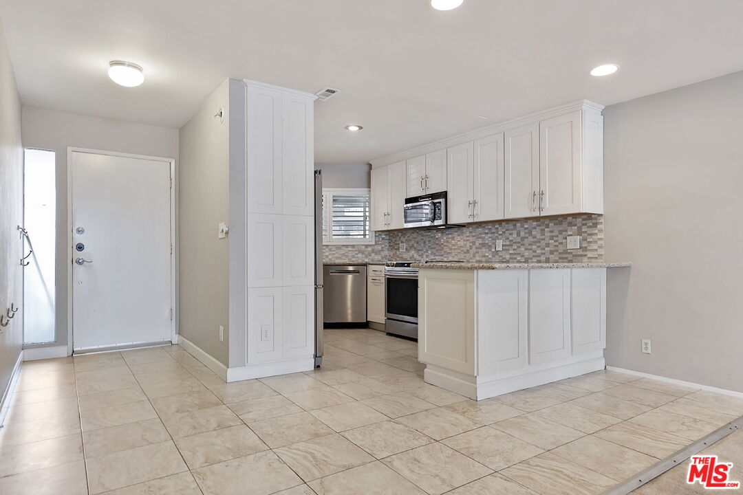 4150 Vía Dolce, Unit 236 Venice, CA 90292 - Photo 9 of 26 a kitchen with stainless steel appliances granite countertop a stove a sink and a refrigerator