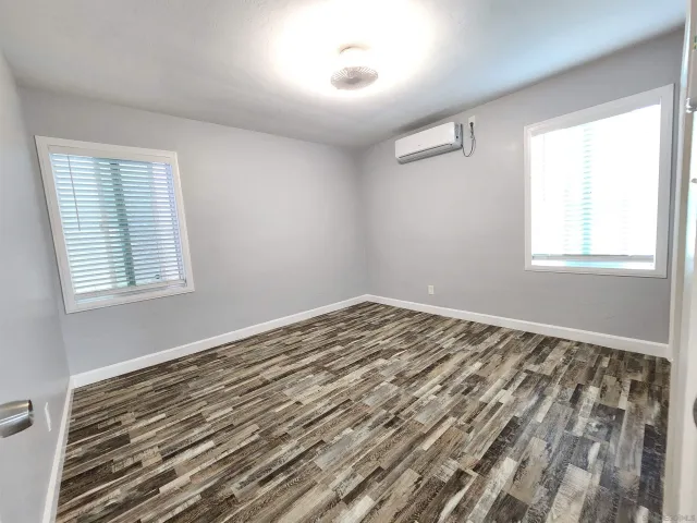 a view of a room with wooden floor and windows