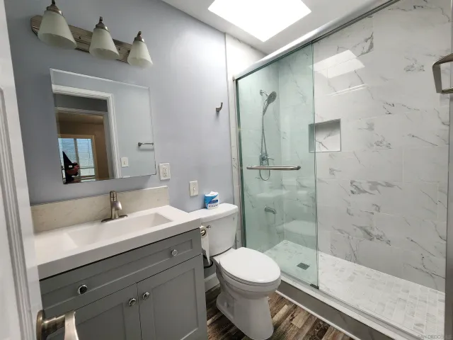a bathroom with a sink a toilet and shower
