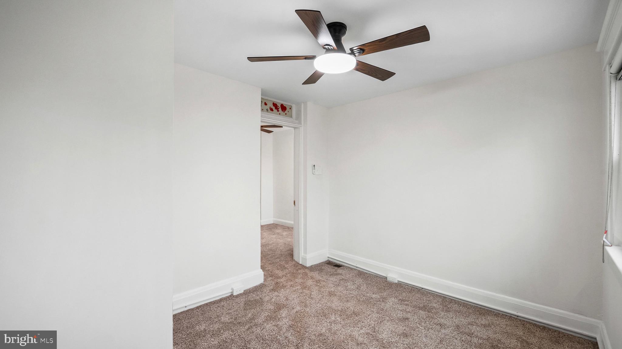 27 North Monastery Avenue Baltimore, MD 21229 - Photo 16 of 26 an empty room with a ceiling fan and carpet