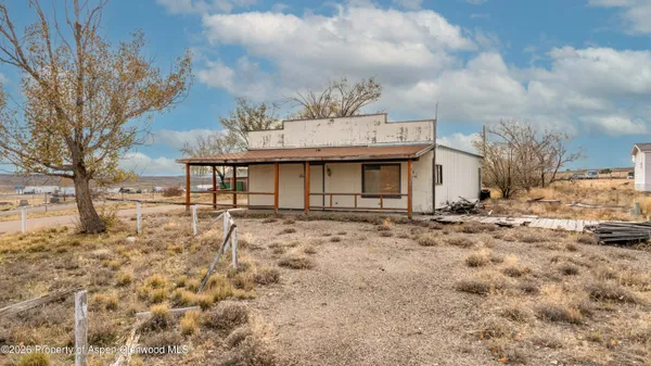 a view of a large white house with a yard covered with snow in front of house
