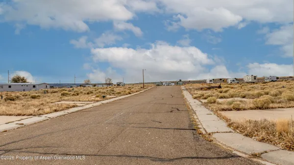 a view of a dry yard with wooden fence