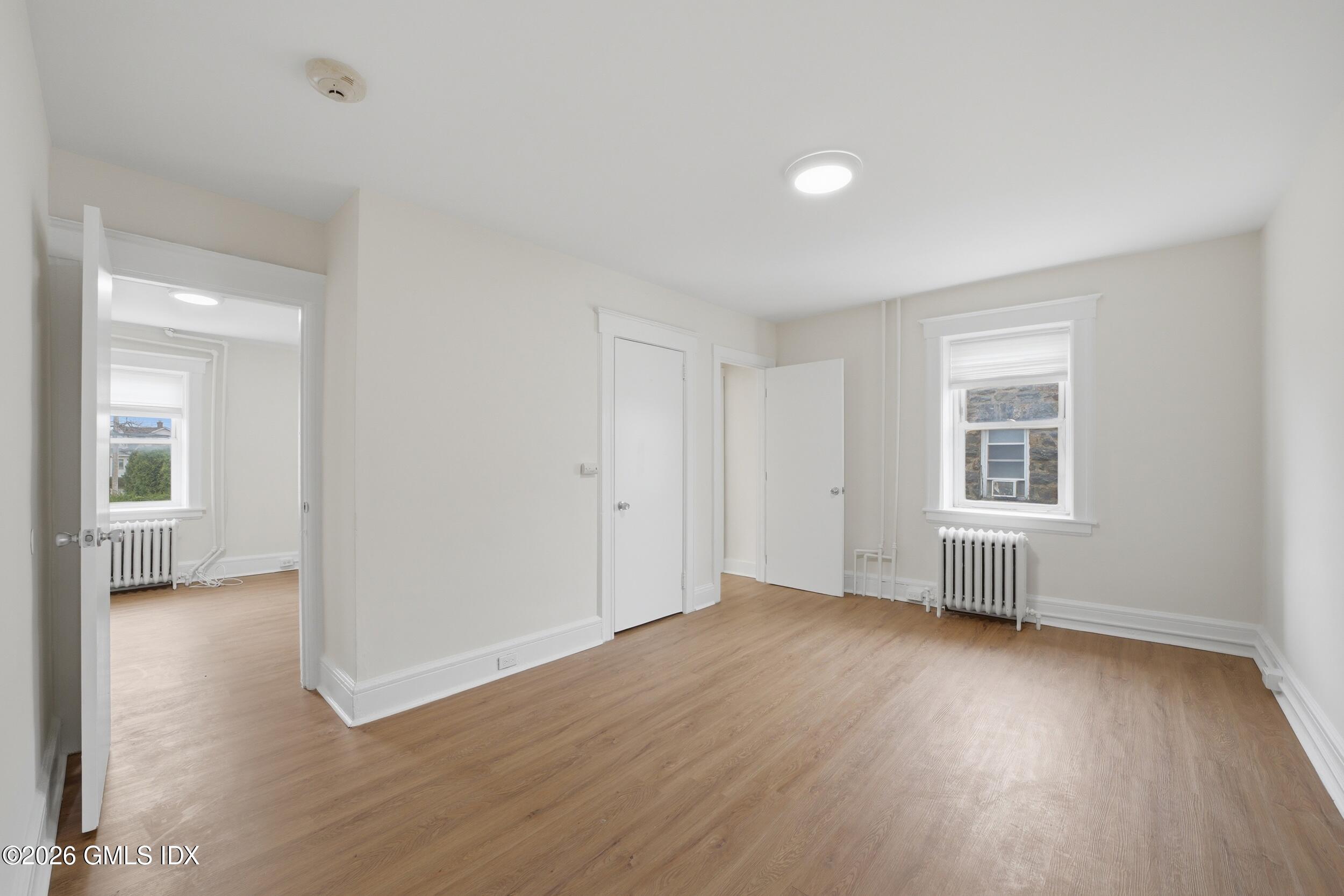 140 Hamilton Avenue, Unit 1 Greenwich, CT 06830 - Photo 2 of 14 a view of an empty room with wooden floor and a window