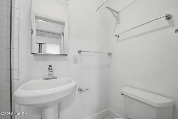 a bathroom with a toilet sink and mirror