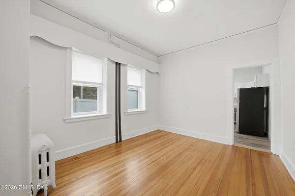 a view of an empty room with wooden floor