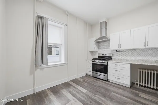 a kitchen with a stove and white cabinets