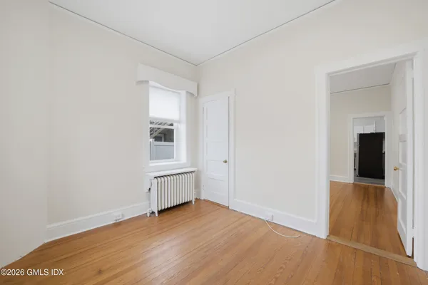 an empty room with wooden floor and cabinet