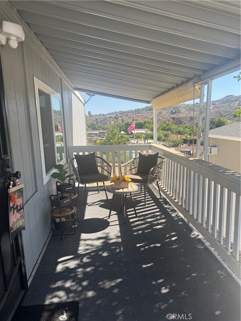15181 Van Buren Boulevard, Unit 47 Riverside, CA 92504 - Photo 16 of 20 a view of a patio with chairs and floor to ceiling window