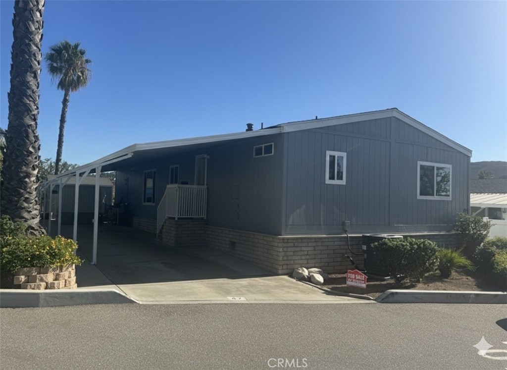 15181 Van Buren Boulevard, Unit 47 Riverside, CA 92504 - Photo 3 of 20 a front view of a house with a yard and garage