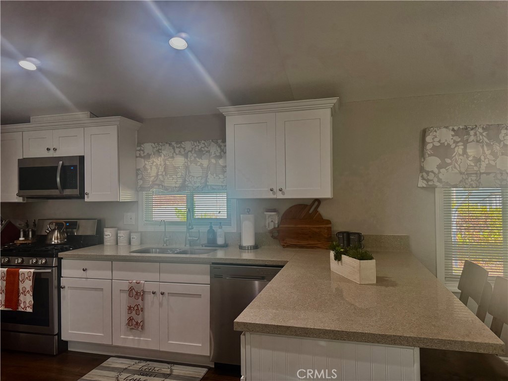 15181 Van Buren Boulevard, Unit 47 Riverside, CA 92504 - Photo 5 of 20 a kitchen with stainless steel appliances granite countertop a sink stove and refrigerator