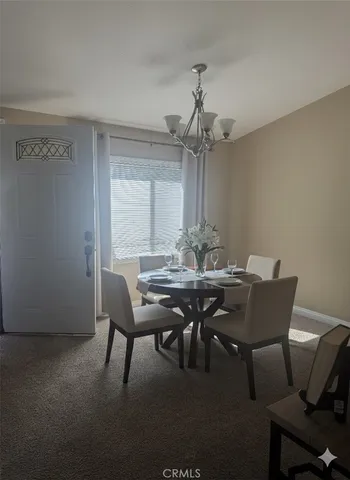 a view of a dining room with furniture and chandelier