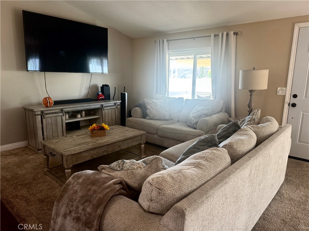 15181 Van Buren Boulevard, Unit 47 Riverside, CA 92504 - Photo 10 of 20 a living room with furniture a flat screen tv and a window