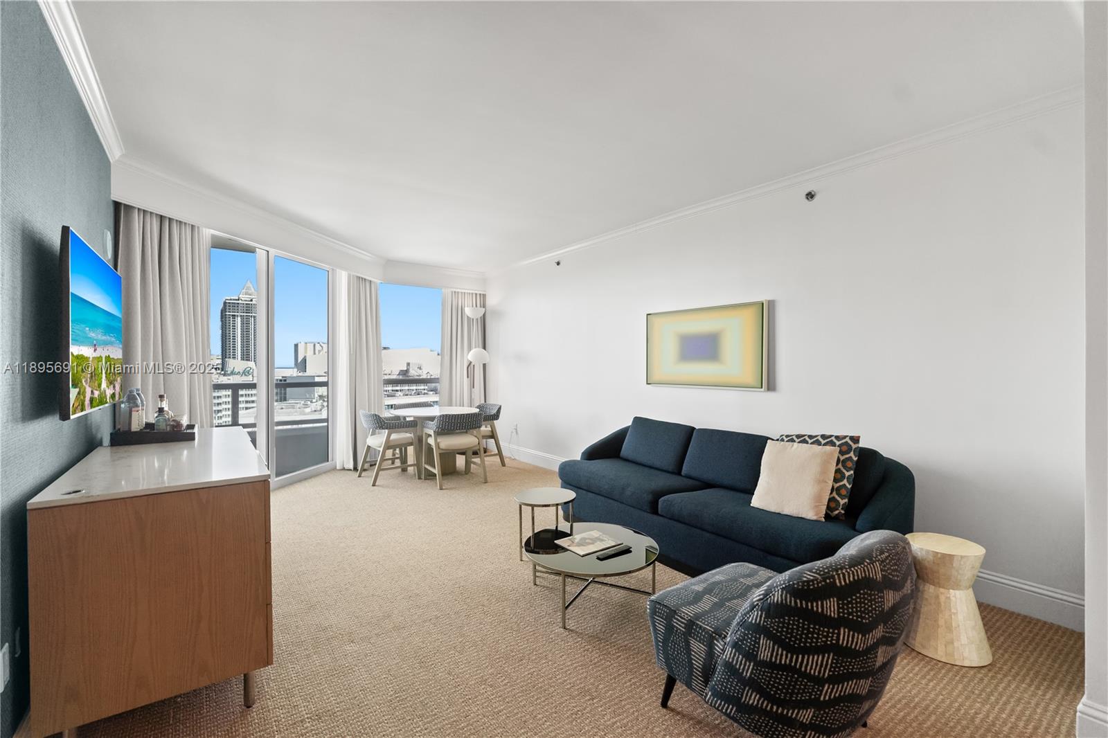 4401 Collins Avenue, Unit 2011 Miami Beach, FL 33140 - Photo 12 of 64 a living room with furniture and a flat screen tv