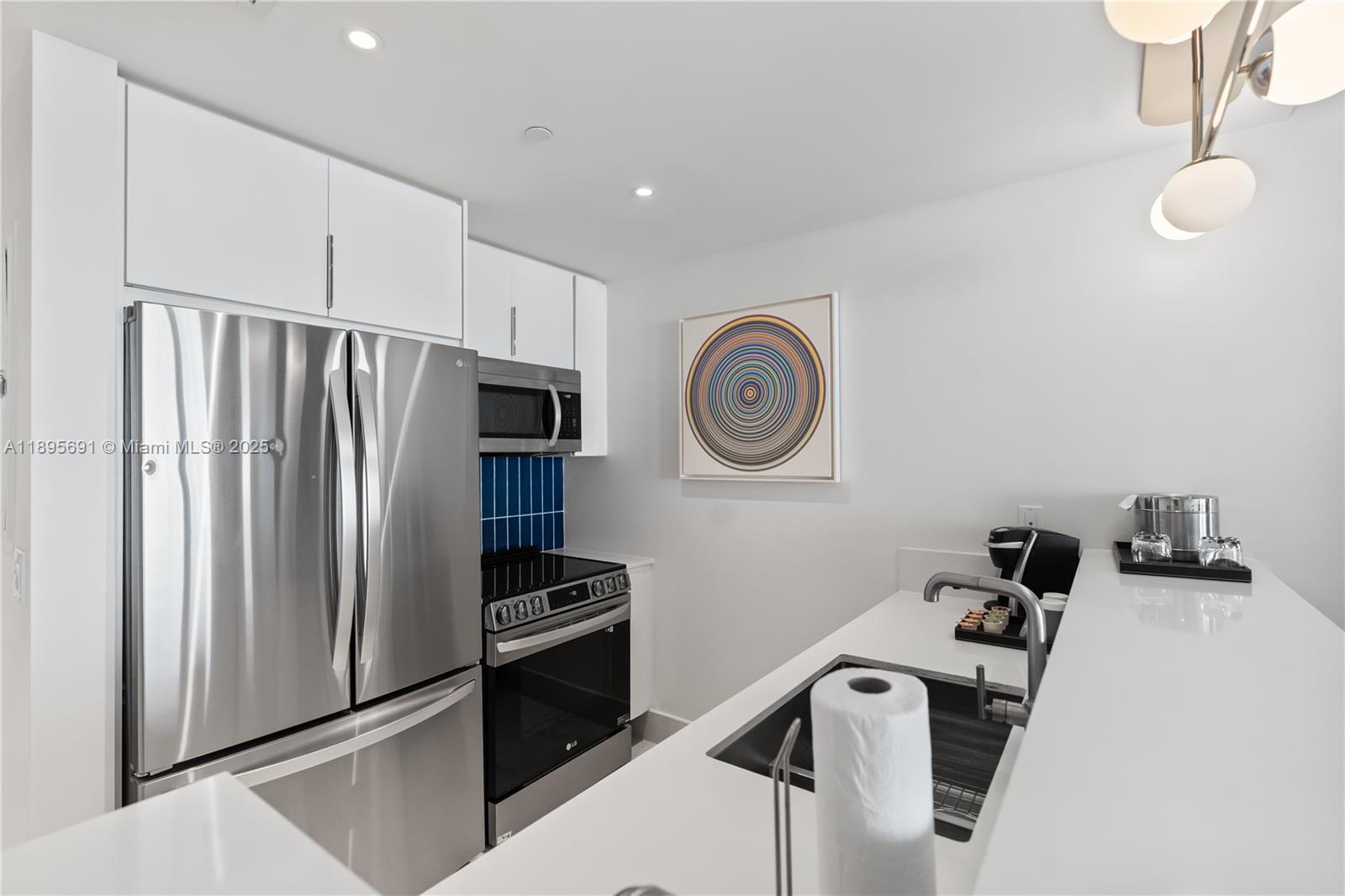 4401 Collins Avenue, Unit 2011 Miami Beach, FL 33140 - Photo 19 of 64 a kitchen with stainless steel appliances granite countertop a refrigerator and a stove top oven