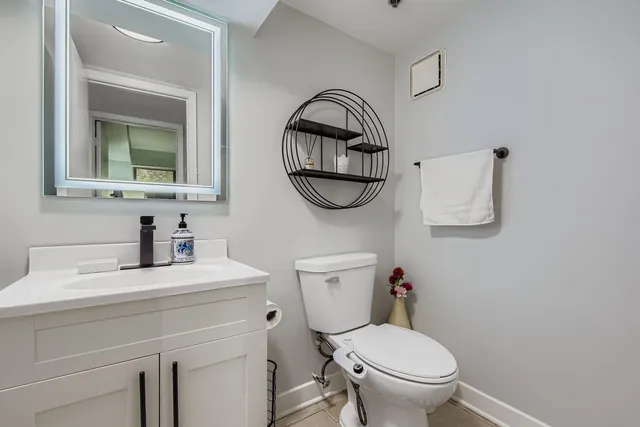 a bathroom with a toilet sink vanity and mirror