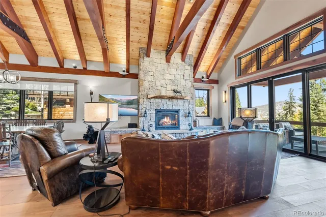 a living room with furniture a fireplace and large windows