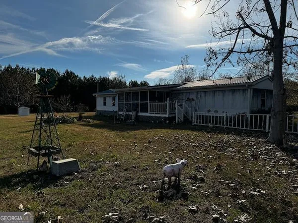 a view of a house with backyard and sitting area