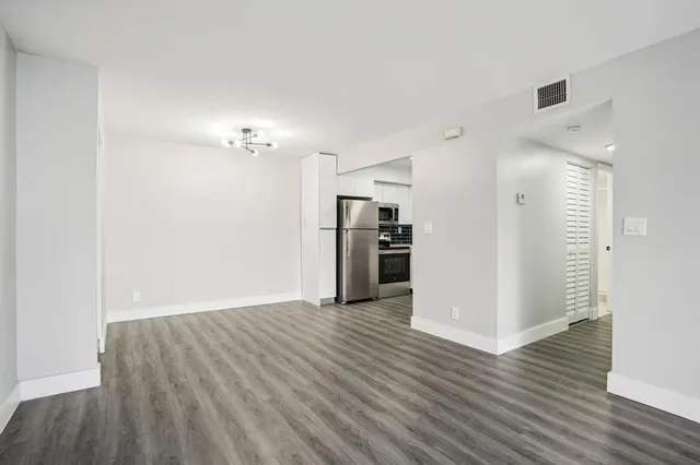 a view of a kitchen with a sink refrigerator and wooden floor