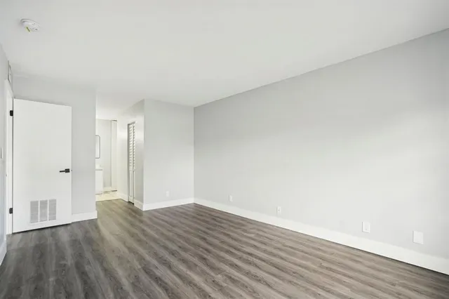 a view of an empty room and wooden floor