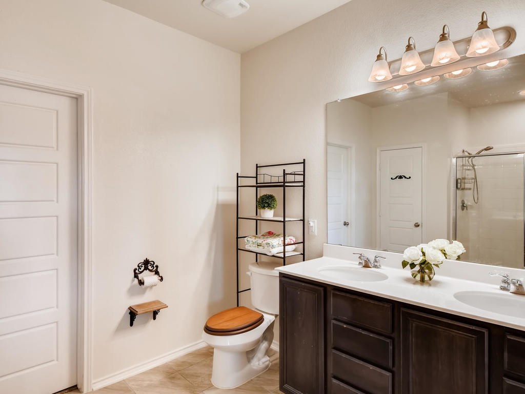 1301 Autumn Sage Way Pflugerville, TX 78660 - Photo 12 of 28 a bathroom with a sink a toilet and a mirror