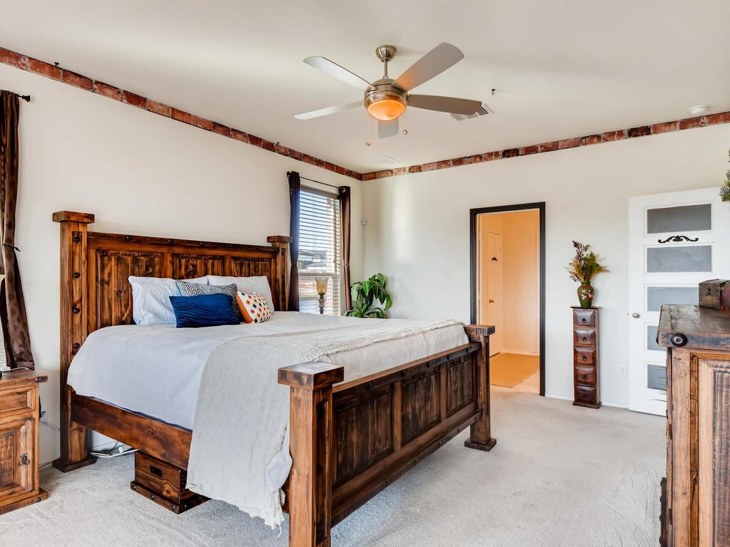1301 Autumn Sage Way Pflugerville, TX 78660 - Photo 15 of 28 a bedroom with a bed and a chandelier