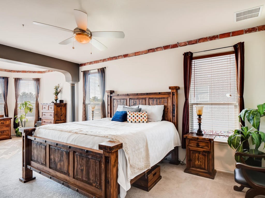 1301 Autumn Sage Way Pflugerville, TX 78660 - Photo 16 of 28 a bedroom with a bed table and a chandelier