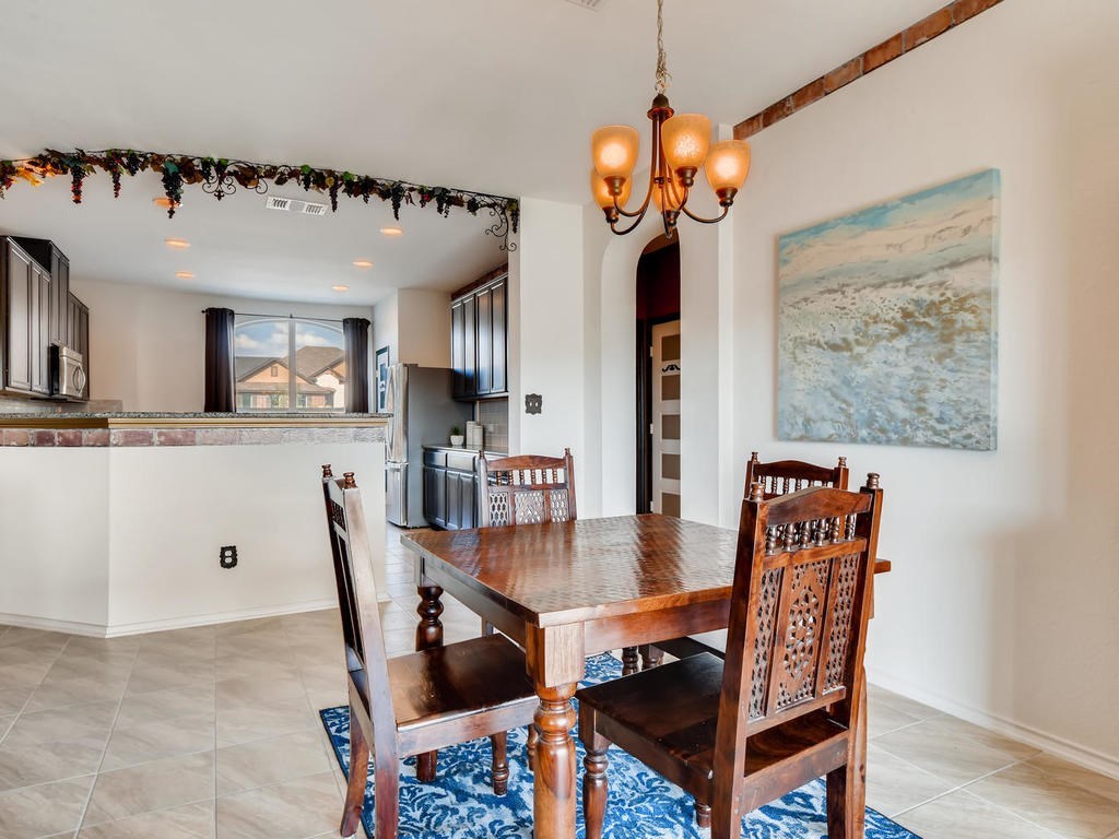 1301 Autumn Sage Way Pflugerville, TX 78660 - Photo 6 of 28 a dining room filled chandelier and wooden floor