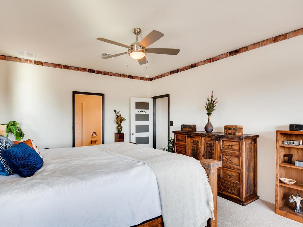 1301 Autumn Sage Way Pflugerville, TX 78660 - Photo 8 of 28 a bedroom with a bed and a chandelier