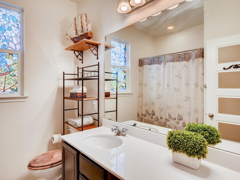 1301 Autumn Sage Way Pflugerville, TX 78660 - Photo 9 of 28 a bathroom with a sink a toilet and shower curtain