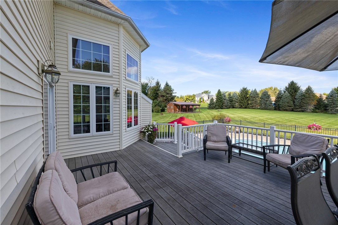 1782 Sweets Corners Road Penfield, NY 14450 - Photo 42 of 49 An elevated wood deck overlooks a manicured green lawn and an in-ground swimming pool.