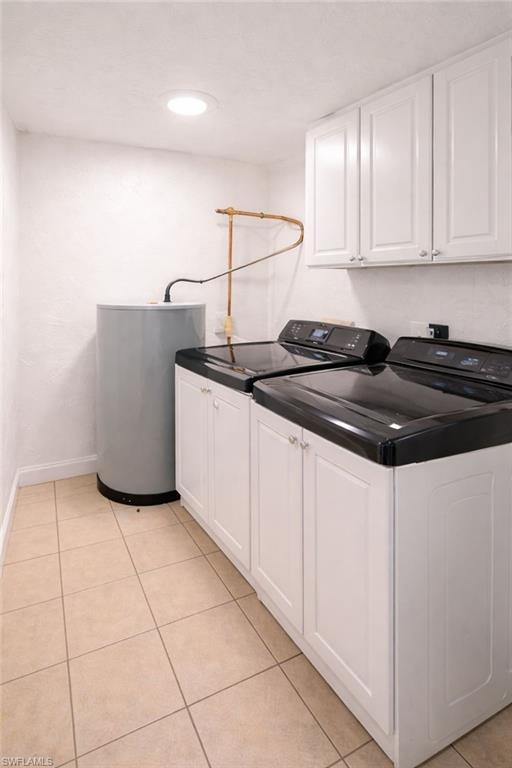 5324 Treetops Drive, Unit G2 Naples, FL 34113 - Photo 5 of 6 Laundry room featuring cabinet space, water heater, light tile patterned floors, washer and clothes dryer, and recessed lighting