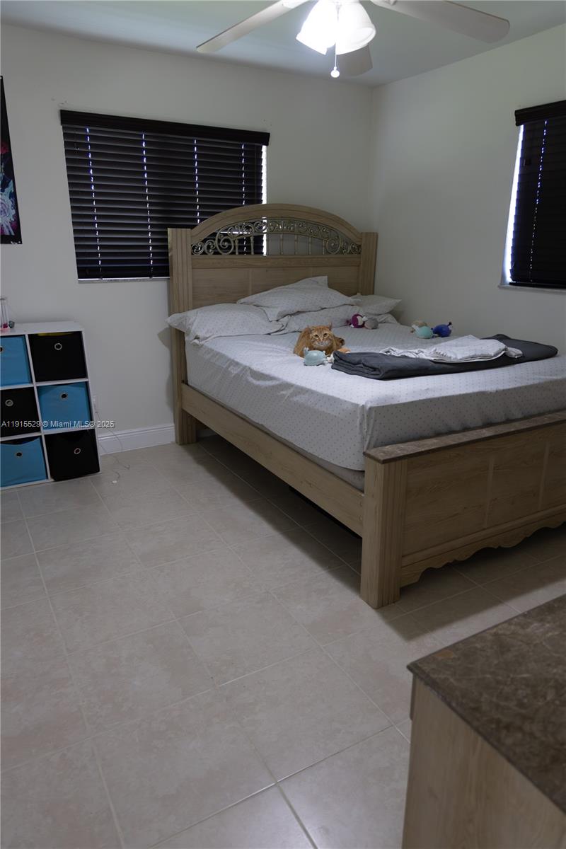 14280 Southwest 285th Street, Unit A Homestead, FL 33033 - Photo 11 of 18 a bedroom with a bed and a chandelier