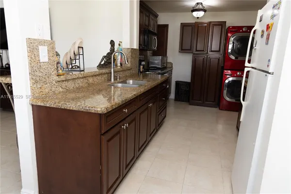 a kitchen with kitchen island granite countertop a sink stove and refrigerator